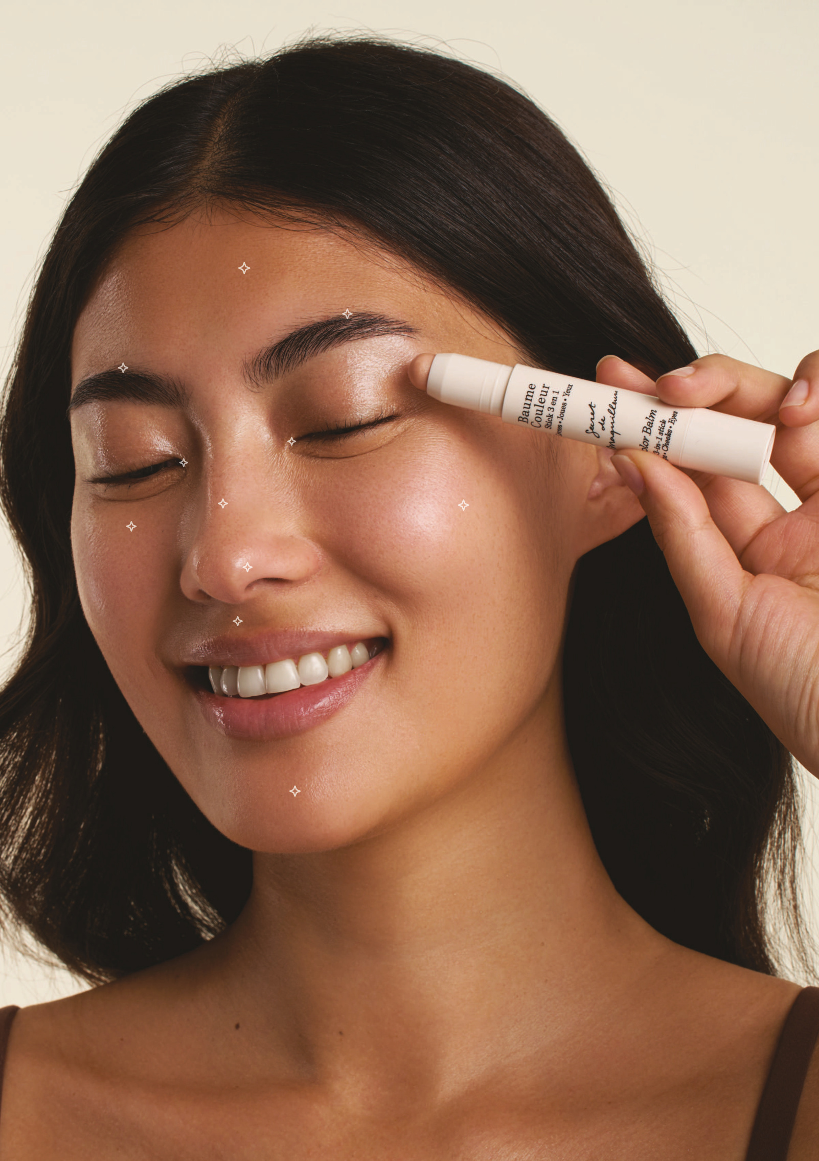 Modelo aplicando Baume Couleur Stick Champagne con los puntos de luz señalados en el rostro